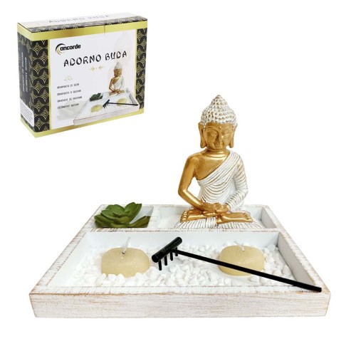 Jardim zen com estátua de Buda em tom neutro, velas acesas e pedras decorativas brancas sobre base de areia.