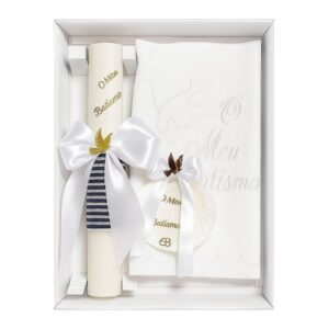 Conjunto de batismo com vela quadrada decorada, toalha branca bordada e concha, com detalhes em azul e laços elegantes.