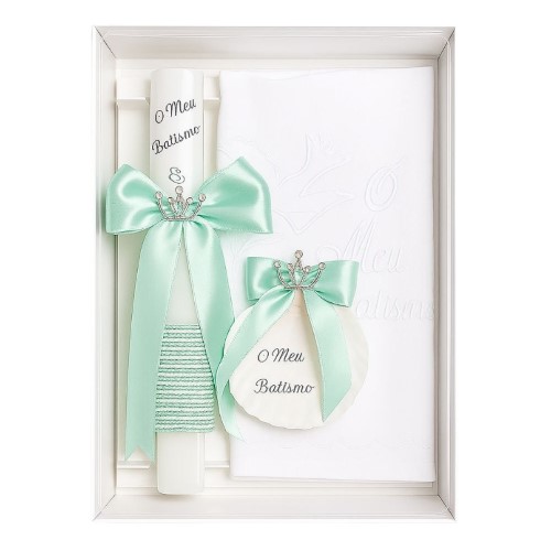 Kit de batismo com vela quadrada decorada, toalha e concha, todos com detalhes em verde e laços elegantes, sobre fundo neutro.