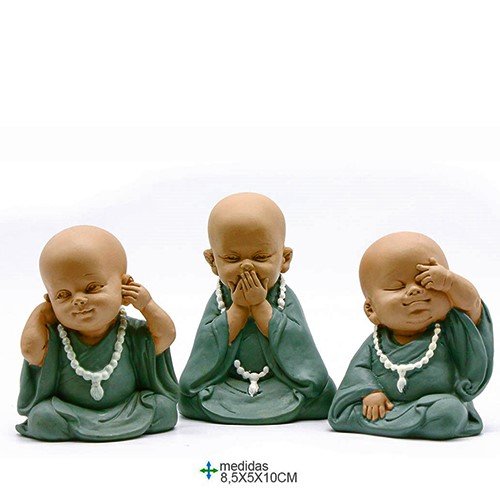 Três estatuetas de monges em resina representando o cego, surdo e mudo, em tons neutros, sobre uma superfície clara