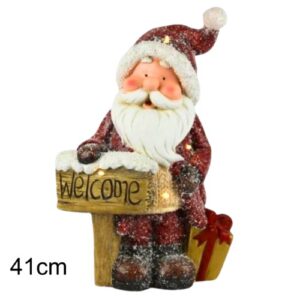 Decoração de Natal com figura do Pai Natal vermelho segurando placa iluminada com a palavra Welcome